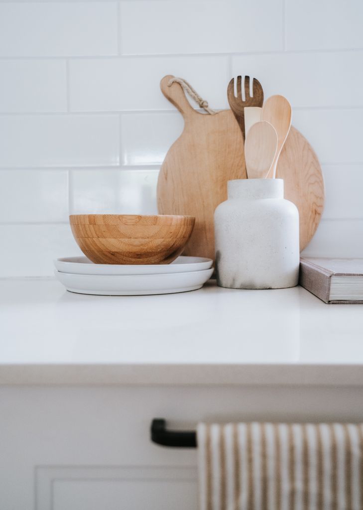 Stylish kitchen countertop featuring cutting boards and wooden tableware, perfect for modern decor.